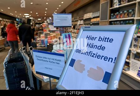 Leipzig, Deutschland. März 2021, 08th. 'Bitte Hände hier desinfizieren!' Liest ein Schild am Eingang einer Leipziger Buchhandlung. Ab diesem Montag können Buchhandlungen unter bestimmten Bedingungen nach einer einwöchigen Sperrung aufgrund von Corona wieder öffnen. Quelle: Hendrik Schmidt/dpa-Zentralbild/ZB/dpa/Alamy Live News Stockfoto