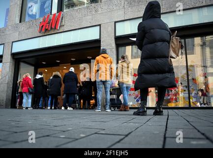 Leipzig, Deutschland. März 2021, 08th. Kunden stehen vor dem Eingang eines H&M-Stores in der Petersstraße. Nach einer einwöchigen Corona-induzierten Lockdown bieten viele Händler mit "Click & Meet" ein neues Konzept an, das ab sofort das Einkaufen mit einem Termin ermöglicht. Quelle: Hendrik Schmidt/dpa-Zentralbild/ZB/dpa/Alamy Live News Stockfoto