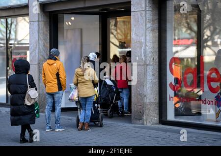 Leipzig, Deutschland. März 2021, 08th. Kunden stehen vor dem Eingang eines H&M-Stores in der Petersstraße. Nach einer einwöchigen Corona-induzierten Lockdown bieten viele Händler mit "Click & Meet" ein neues Konzept an, das ab sofort das Einkaufen mit einem Termin ermöglicht. Quelle: Hendrik Schmidt/dpa-Zentralbild/ZB/dpa/Alamy Live News Stockfoto