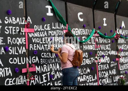 Mexiko-Stadt, Mexiko. März 2021, 07th. Eine Frau, nimmt an einer Performance feministischer Gruppen Teil, um Namen von Opfern von Frauenmorden zu schreiben und Blumen aus Protest gegen Geschlechtergewalt zu platzieren, im Rahmen der Proteste des Internationalen Frauentags im Nationalpalast am 7. März 2021 in Mexiko-Stadt, Mexiko (Foto: Eyepix/Sipa USA) Quelle: SIPA USA/Alamy Live News Stockfoto