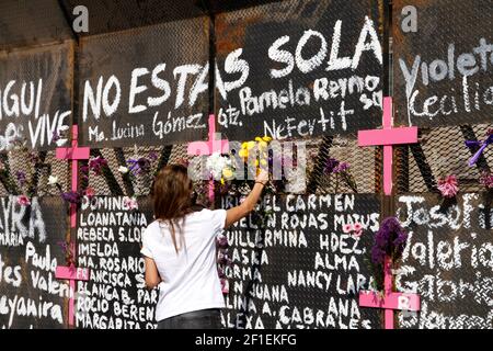 Mexiko-Stadt, Mexiko. März 2021, 07th. Eine Frau, nimmt an einer Performance feministischer Gruppen Teil, um Namen von Opfern von Frauenmorden zu schreiben und Blumen aus Protest gegen Geschlechtergewalt zu platzieren, im Rahmen der Proteste des Internationalen Frauentags im Nationalpalast am 7. März 2021 in Mexiko-Stadt, Mexiko (Foto: Eyepix/Sipa USA) Quelle: SIPA USA/Alamy Live News Stockfoto