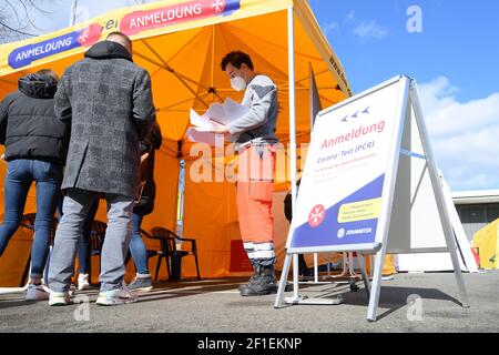 Dresden, Deutschland. März 2021, 08th. Ein Mitarbeiter der Johanniter-Unfall-Hilfe steht vor einem Zelt auf dem Messegelände zu Beginn eines Schnellantigen-Tests auf das Coronavirus und nimmt Registrierungen entgegen. Ab sofort können Dresdner einmal pro Woche kostenlos getestet werden. Quelle: Sebastian Kahnert/dpa-Zentralbild/dpa/Alamy Live News Stockfoto