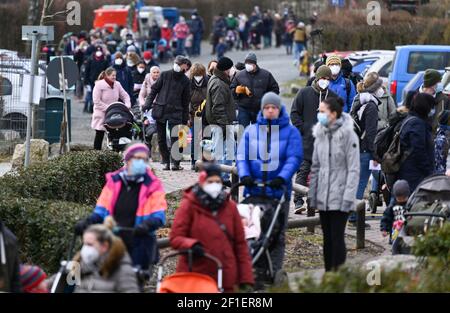 Kronberg, Deutschland. März 2021, 08th. Vor der Wiedereröffnung des Opel-Zoos stehen Familien Schlange. Die umfangreichen Maßnahmen zum Schutz vor Infektionen mit dem Coronavirus sind in Hessen etwas gelockert. Am ersten Eröffnungstag nach der Sperre war der Andrang großartig. Die Besucher konnten ihre Tickets für den Zoobesuch über ein Online-Ticketsystem kaufen. Kredit: Arne Dedert/dpa/Alamy Live Nachrichten Stockfoto