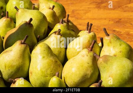 Birnen in Sonnenstrahlen in Holzkiste am Stand des lokalen Bio-Bauernmarktes in Paris, Frankreich. Stockfoto