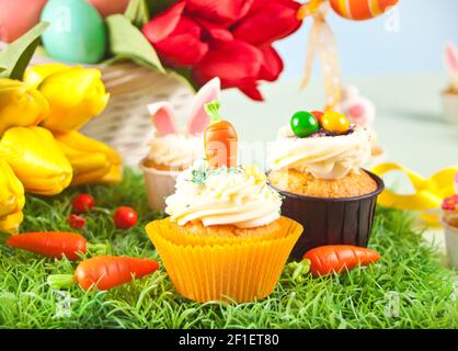 Ostern lustige Cupcakes mit Zuckerkarotte und Häschen Ohren. Osterfest Festtisch Stockfoto