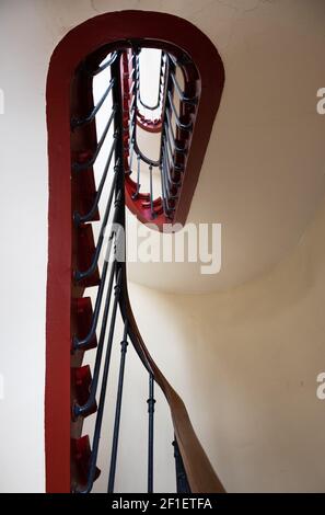 Frauenportrait. Geländer einer Wendeltreppe in einem alten Pariser Haus, das wie eine weibliche Silhouette aussieht. Stockfoto