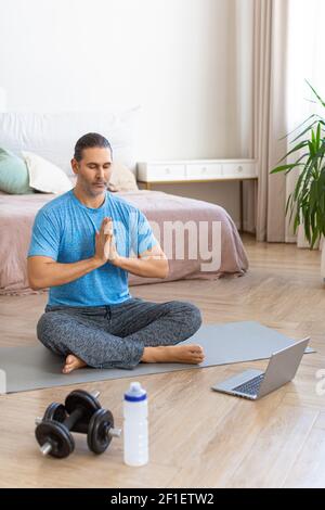 Mann während des Online-Dampfgarens. Meditationspraxis - Gebetshaltung. Vertikales Foto. Stockfoto