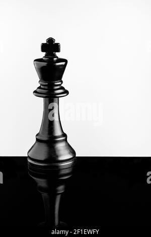 Black King auf schwarzem Acryl mit Reflektion und weißem Hintergrund Stockfoto