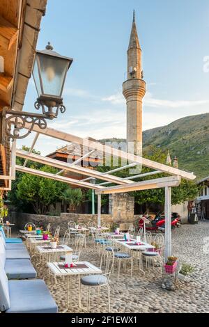 Café im Freien und Minarett der Moschee in der Altstadt von Mostar, BiH Stockfoto