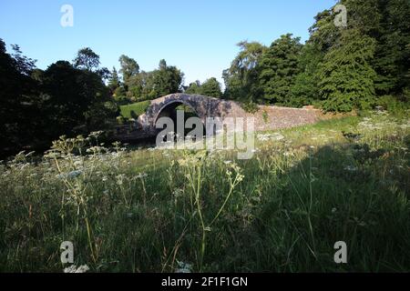 Die Brig o Doon, Alloway, South Ayrshire, Schottland, UK.Manchmal auch als Auld Brig oder Old Bridge of Doon, ist eine spätmittelalterliche Brücke und eine Kategorie-A-Struktur und ist die ursprüngliche 15th-Jahrhundert-Kopfsteinpflaster-Brücke. Es wurde im Robert Burns Gedicht "The Tale of Tam o Shanter" verewigt.unterhalb der Brücke befinden sich die gepflegten Gärten des Brig o Doon Hotels Stockfoto