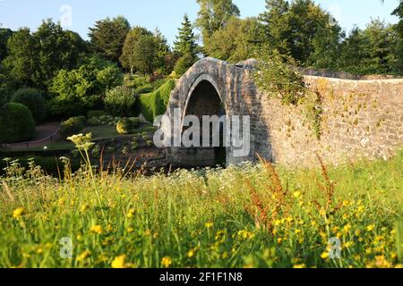 Die Brig o Doon, Alloway, South Ayrshire, Schottland, UK.Manchmal auch als Auld Brig oder Old Bridge of Doon, ist eine spätmittelalterliche Brücke und eine Kategorie-A-Struktur und ist die ursprüngliche 15th-Jahrhundert-Kopfsteinpflaster-Brücke. Es wurde im Robert Burns Gedicht "The Tale of Tam o Shanter" verewigt.unterhalb der Brücke befinden sich die gepflegten Gärten des Brig o Doon Hotels Stockfoto