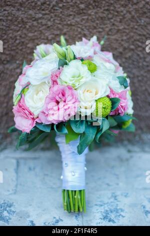 Hochzeit Bouquet von rosa Blumen, weißen Blumen und Grün ist auf dem braunen und grauen Hintergrund. Hochzeit Floristik. Stilvoller Strauß Rosen, Pfingstrosen Stockfoto