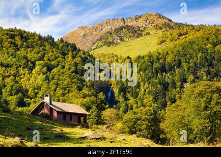 Panoramablick auf die Berge, die das Tal von Artiga de Lin umgeben, wo Sie in ihnen die Hochgebirgshütte und einen Wasserfall sehen können. Katalonien, Stockfoto