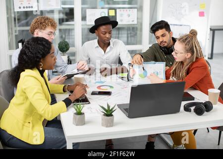 Multirassisches Team von jungen kreativen Spezialisten, mit Online-Chat mit Chef oder Kollegen Stockfoto