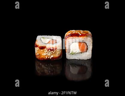 Sushi-Rollen auf schwarzem Hintergrund, japanische Küche. Stockfoto