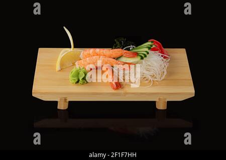 japanische Lebensmittel Sashimi roh geschnittener Fisch, Schalentiere oder Krebstiere auf Holzbrett. Stockfoto