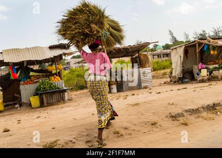 Afrikanische Frau trägt ein Bündel auf ihrem Kopf in einem Kleiner Markt in der Nähe von Watamu in Kenia Stockfoto