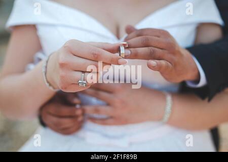 Ein flacher Fokus eines frisch verheirateten Paares umarmen und Ringe an die Finger in einem Park legen Stockfoto