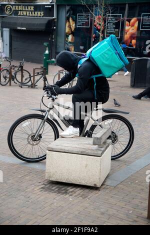 London, Hackney, Großbritannien. Deliveroo Radfahrer warten auf Lieferung abholen Stockfoto
