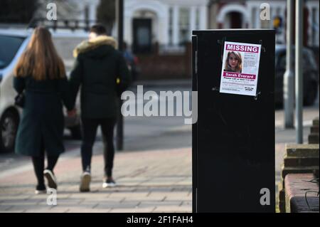 Ein Paar geht an einem verschwundenen Plakat entlang der A205 Poynders Road, an der Kreuzung mit Cavendish Road in Clapham, Süd-London, vorbei, nachdem eine neue Videoüberwachung der vermissten Frau Sarah Everard, 33, entdeckt wurde. Sarah verließ das Haus eines Freundes in Clapham, Süd-London, am Mittwochabend um etwa 9pm Uhr und begann zu Fuß nach Brixton. Bilddatum: Montag, 8. März 2021. Stockfoto