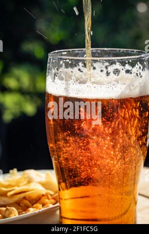 Ein erfrischendes Bier in der Nachmittagssonne gießen Stockfoto