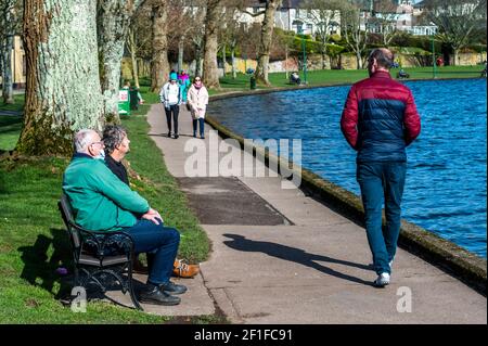 Cork, Irland. März 2021, 8th. Die Menschen stiegen heute an einem kalten, aber sonnigen Tag auf den Lough in Cork ab. Die meisten Menschen beobachteten soziale Distanzierung. Quelle: AG News/Alamy Live News Stockfoto