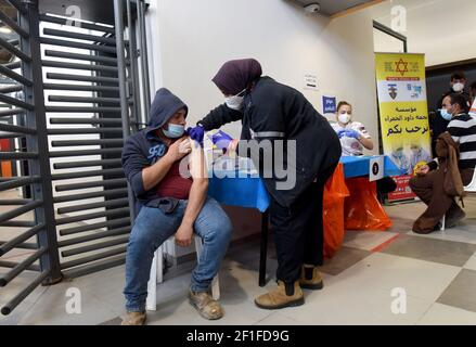 Lamed Hei Checkpoint, Palästina, 8th. März 2021. Ein Sanitäter der israelischen Agentur für den Notfall "Magen David Adam" impft am Montag, den 8. März 2021, einen palästinensischen Arbeiter mit der ersten Dosis des Impfstoffes "Moderna COVID-19" am Checkpoint Lamed Hei zwischen Gusch Etzion und Beit Shemesh ein. Israel startete eine zweiwöchige Kampagne, um etwa 100.000 palästinensische Arbeiter aus dem Westjordanland zu impfen, die Arbeitsgenehmigungen in Israel und jüdischen Siedlungen besitzen. Kredit: UPI/Alamy Live Nachrichten Stockfoto