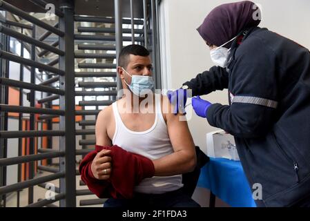 Lamed Hei Checkpoint, Palästina, 8th. März 2021. Ein Sanitäter der israelischen Agentur für den Notfall "Magen David Adam" impft am Montag, den 8. März 2021, einen palästinensischen Arbeiter mit der ersten Dosis des Impfstoffes "Moderna COVID-19" am Checkpoint Lamed Hei zwischen Gusch Etzion und Beit Shemesh ein. Israel startete eine zweiwöchige Kampagne, um etwa 100.000 palästinensische Arbeiter aus dem Westjordanland zu impfen, die Arbeitsgenehmigungen in Israel und jüdischen Siedlungen besitzen. Kredit: UPI/Alamy Live Nachrichten Stockfoto