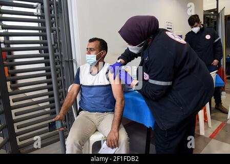 Lamed Hei Checkpoint, Palästina, 8th. März 2021. Ein Sanitäter der israelischen Agentur für den Notfall "Magen David Adam" impft am Montag, den 8. März 2021, einen palästinensischen Arbeiter mit der ersten Dosis des Impfstoffes "Moderna COVID-19" am Checkpoint Lamed Hei zwischen Gusch Etzion und Beit Shemesh ein. Israel startete eine zweiwöchige Kampagne, um etwa 100.000 palästinensische Arbeiter aus dem Westjordanland zu impfen, die Arbeitsgenehmigungen in Israel und jüdischen Siedlungen besitzen. Kredit: UPI/Alamy Live Nachrichten Stockfoto