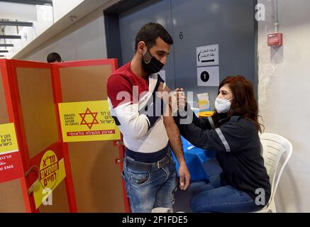 Lamed Hei Checkpoint, Palästina, 8th. März 2021. Ein Sanitäter der israelischen Agentur für den Notfall "Magen David Adam" impft am Montag, den 8. März 2021, einen palästinensischen Arbeiter mit der ersten Dosis des Impfstoffes "Moderna COVID-19" am Checkpoint Lamed Hei zwischen Gusch Etzion und Beit Shemesh ein. Israel startete eine zweiwöchige Kampagne, um etwa 100.000 palästinensische Arbeiter aus dem Westjordanland zu impfen, die Arbeitsgenehmigungen in Israel und jüdischen Siedlungen besitzen. Kredit: UPI/Alamy Live Nachrichten Stockfoto