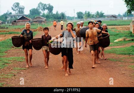 Dorfbewohner auf dem Weg zum Fischen im lokalen Fluss mit ihren Fischkörben, ländliches Südvietnam, Juni 1980 Stockfoto