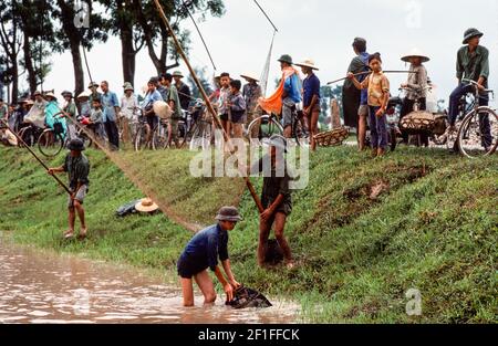 Dorfbewohner, die in den Fischteichen mit Netzen und Fischkörben fischen, ländliches Südvietnam, Juni 1980 Stockfoto