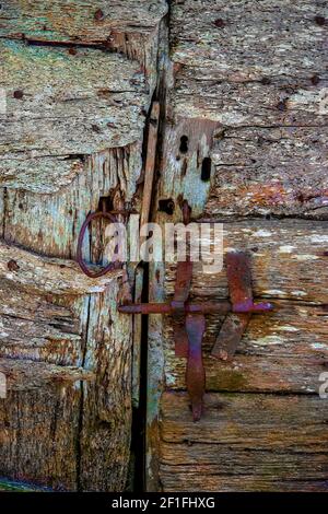 Detail einer alten Scheunentür, die den Bolzen und zeigt Griff in geschlossener Position Stockfoto