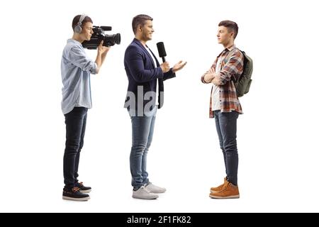 In voller Länge Profilaufnahme eines Reporters mit einem Mikrofon Und ein Kameramann interviewte einen männlichen Schüler isoliert auf weiß Hintergrund Stockfoto