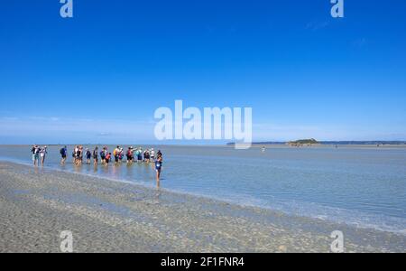 Mont Saint Michel, Frankreich - 29. August 2019: Wandergruppe bei Ebbe in der Bucht auf dem Mont Saint-Michel in der Basse-Normandie, Frankreich Stockfoto