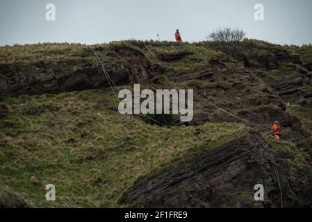 Edinburgh, Schottland, Großbritannien. März 2021, 8th. Ein Arbeiter, der seinen Weg zu seinen Kollegen an der Spitze der "Radical Road" auf Arthur's Seat, Edinburgh. Die Radical Road ist wegen der anhaltenden Gefahr von Steinschlag gesperrt. Laut Historic Scotland, das die Situation überwacht, fielen in einem Jahr 65 Tonnen Gestein auf den Weg. Kredit: Gayle McIntyre/Alamy Live Nachrichten Stockfoto