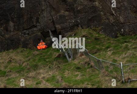 Edinburgh, Schottland, Großbritannien. März 2021, 8th. A Workman taking a break from work on 'The Radical Road' on Arthur's Seat, Edinburgh, 8. März 2021. Die Radical Road ist wegen der anhaltenden Gefahr von Steinschlag gesperrt. Laut Historic Scotland, das die Situation überwacht, fielen in einem Jahr 65 Tonnen Gestein auf den Weg. Kredit: Gayle McIntyre/Alamy Live Nachrichten Stockfoto