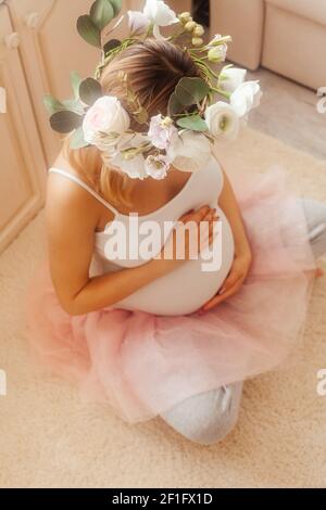 Schwangere Frau bleiben im Zimmer und schauen Sie sich die an Bauch Stockfoto