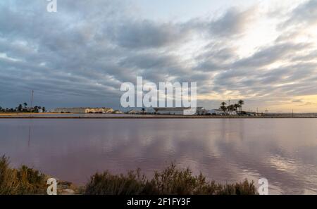 San Pedro del Pinatar, Spanien - 23. Februar 2021: Industrielle Salzfabrik und salinen in San Pedro del Pinatar in Murcia bei Sonnenuntergang Stockfoto