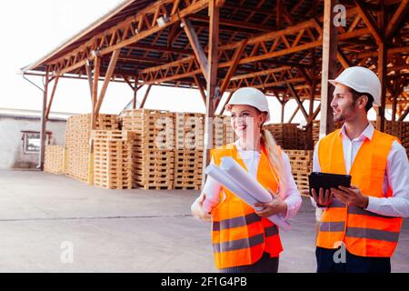 Junge Ingenieurin Frau und ihre untergeordnete Arbeiterin in der Fabrik Stockfoto