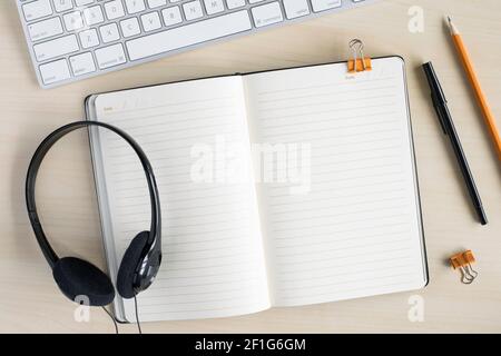 Business-Arbeitstisch-Modell mit leerem Notizbuch für Text in der Mitte. Arbeiten oder studieren Konzept. Flaches Lay auf Schreibtisch mit Computer-Tastatur, Kopf Stockfoto