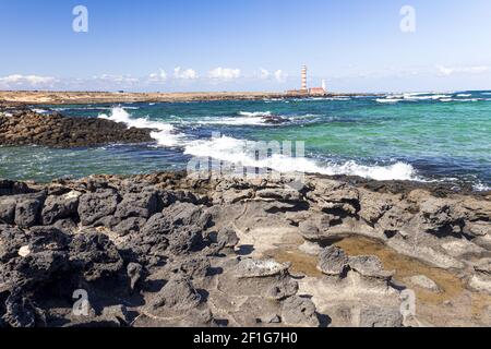 Vulkanische Felsen gegenüber dem Faro De Toston in der Nähe von El Cotillo, Fuerteventura, Kanarische Inseln Stockfoto