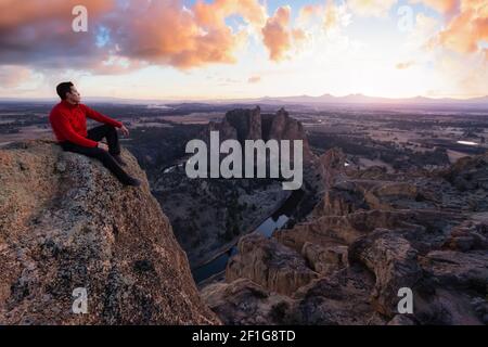 Mann, der auf einem Berg steht, genießt ein Wunderschöne Landschaft Stockfoto