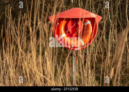 Orange Rettungsring gesehen Offshore durch gelbes Gras im Killarney National Park, County Kerry, Irland. Der Fänger im Roggenkonzept. Stockfoto