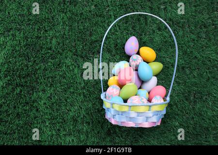 Ostereier Korb gefüllt mit bunten Ostereiern auf grün Gras Stockfoto