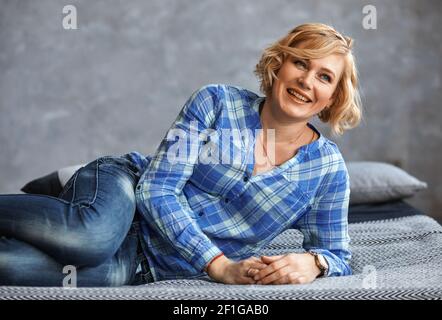 Schöne Frau ist entspannend auf dem Bett liegen Stockfoto