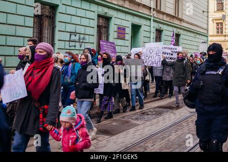 Lviv, Ukraine - 8. März 2021: Feministischer marsch für Gleichberechtigung gegen Sexismus zum Internationalen Frauentag. Aktivisten umgeben von Polizisten Stockfoto