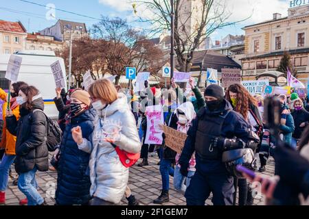 Lviv, Ukraine - 8. März 2021: Feministischer marsch für Gleichberechtigung gegen Sexismus zum Internationalen Frauentag. Aktivisten umgeben von Polizisten Stockfoto