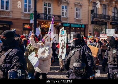 Lviv, Ukraine - 8. März 2021: Feministischer marsch für Gleichberechtigung gegen Sexismus zum Internationalen Frauentag. Aktivisten umgeben von Polizisten Stockfoto