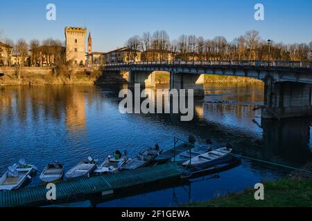 Boote dockten bei Sonnenuntergang in der Nähe einer Brücke über den Fluss Adda an, Pizzighettone, Cremona, Lombardei, Italien Stockfoto